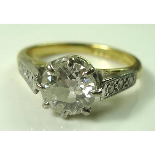 849 - A diamond solitaire ring, the central diamond approximately 1.2ct, 6.57mm diameter by 4mm, flanked t... 