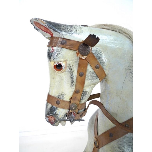 852 - An Edwardian rocking horse, the painted dappled grey body with leather bridle to head, leather and c... 