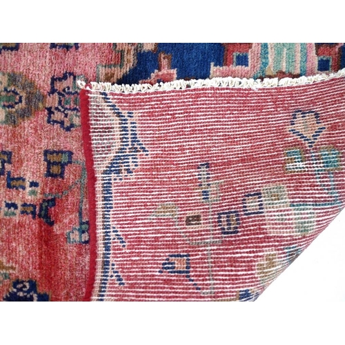 853 - A Hamadan rug with red ground and three blue medallions, 167 by 83cm.