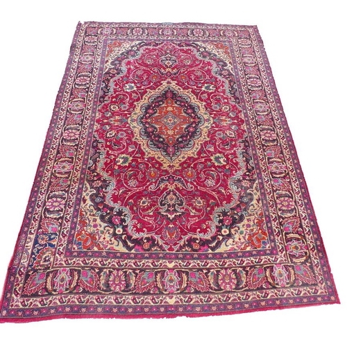 921 - A Meshed rug with dark red ground, cream and black foliate decoration, 308 by 212cm.