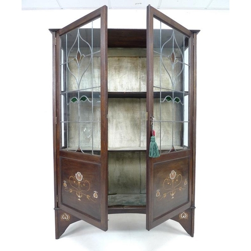 922 - An Art Nouveau mahogany, fruitwood and metal inlaid display cabinet, twin leaded stained glass doors... 