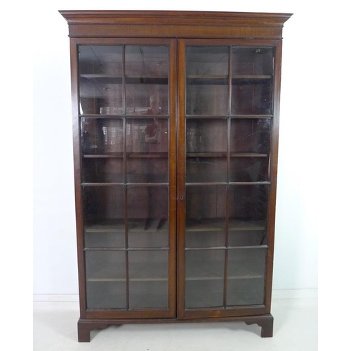 927 - An Edwardian mahogany bookcase, outswept cornice over two full height astragal glazed doors with eig... 