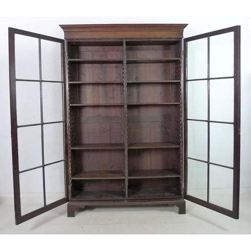 927 - An Edwardian mahogany bookcase, outswept cornice over two full height astragal glazed doors with eig... 