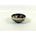 A Moorcroft bowl, designed by Philip Gibson, decorated with pink lilies on navy blue ground, base ma... 