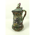 A Minton Majolica lidded jug, the shell moulded lid with jester's head finial, Britannia metal mount... 