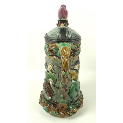 502 - A Minton Majolica lidded jug, the shell moulded lid with jester's head finial, Britannia metal mount... 