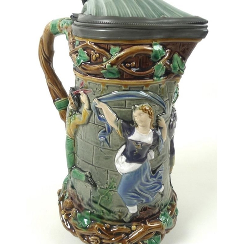 502 - A Minton Majolica lidded jug, the shell moulded lid with jester's head finial, Britannia metal mount... 