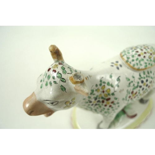 527 - A Staffordshire pottery cow creamer, late 19th century, with painted floral decoration, on an oval b... 