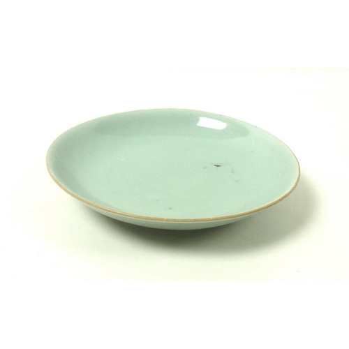 533 - A Chinese celadon / duck egg blue dish with iron spots and pitting and a faux six character undergla... 