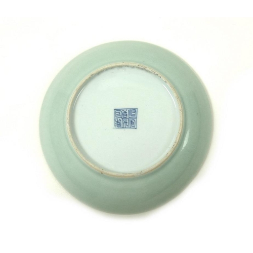 533 - A Chinese celadon / duck egg blue dish with iron spots and pitting and a faux six character undergla... 