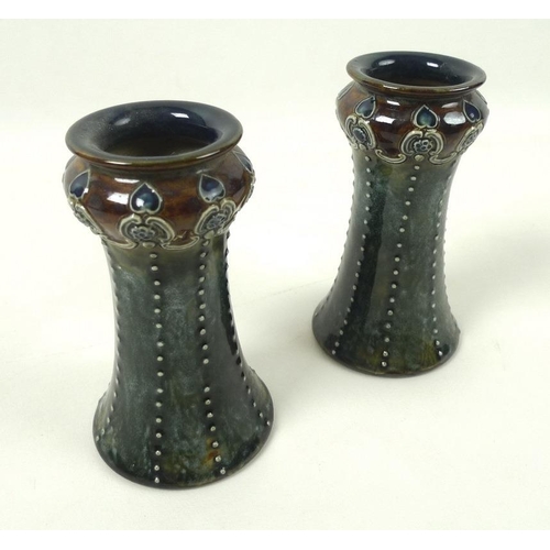 544 - A pair of Art Nouveau Royal Doulton vases, of waisted form with flared mouth and foot, the body with... 