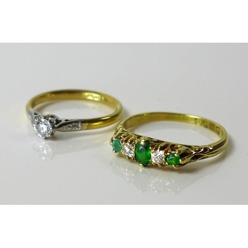 797 - An 18ct gold, emerald and diamond ring, the central oval emerald flanked by two diamonds and smaller... 