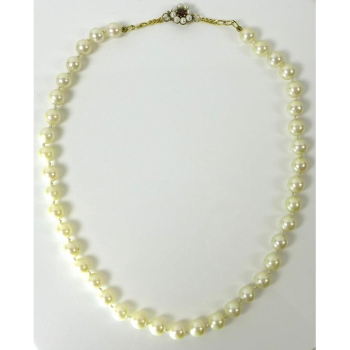 799 - A single strand of forty cultured pearls, with 9ct gold clasp set with a central garnet surrounded b... 