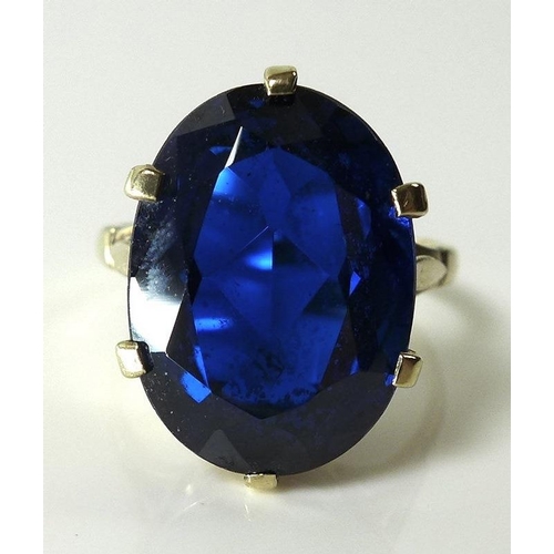 813 - A 9ct gold ring set with large oval cut blue stone, pierced claw setting and stylised leaf detailing... 