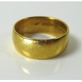 A 22ct gold ring, the wide gold bank marked to the interior, size N/O, 7.4g.
