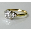 A platinum and diamond solitaire ring, with four baguette cut diamonds of graduating size on each sh... 