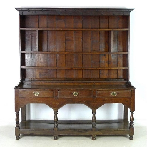 950 - An 18th century oak dresser with plate rack, the moulded cornice with iron cup hooks, the base with ... 