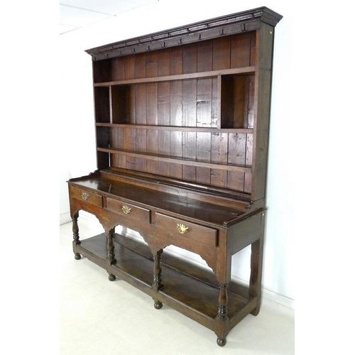 950 - An 18th century oak dresser with plate rack, the moulded cornice with iron cup hooks, the base with ... 