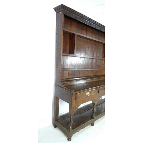 950 - An 18th century oak dresser with plate rack, the moulded cornice with iron cup hooks, the base with ... 