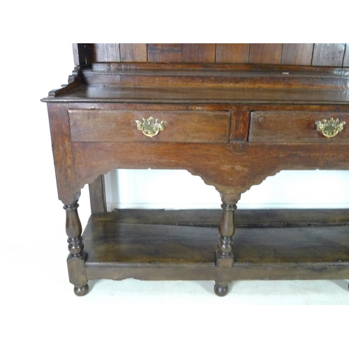 950 - An 18th century oak dresser with plate rack, the moulded cornice with iron cup hooks, the base with ... 