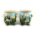 A pair of planters decorated with arum lilies on a duck egg blue ground, yellow rim and pink interio... 