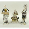 A pair of 18th / 19th century porcelain figurines, modelled as a lady selling fruit and holding a pa... 