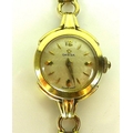 A gold plated Omega lady's wristwatch on slender 9ct gold strap, circular silvered dial, gold hands ... 