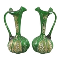 A pair of Victorian green glass ewers, with mirrored decoration of Lily of the Valley, 22.5cm high. ... 