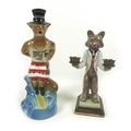 A Continental ceramic candlestick in the form of a wolf holding out two candlesticks, wearing grey t... 