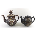 A Victorian bargeware teapot, the finial in the form of a teapot, with applied floral medallion to b... 
