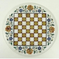 A decorative hardstone inlaid chess board, with circular outline, coloured and white squares, floral... 