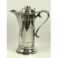 An ecclesiastical silver plated flagon of large proportions, with wide spout, circular stepped hinge... 