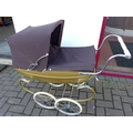 A Silver Cross child's dolls pram, with cream livery, brown hood and covers, white wheels and chrome... 