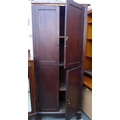 A mahogany corner cabinet with brass drop handles.