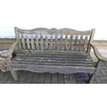 A wooden two seater garden bench, with slat back and seat and carved decoration to top rail.
