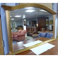 A modern gilt framed over mantel mirror, with arched rectangular bevelled plate.
