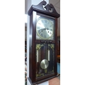 A 20th century wall clock, with wooden case and twin pendulums, the brass face with Roman numerals a... 