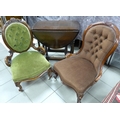 Two Victorian spoon back nursing chairs with button backs, each raised on cabriole legs and together... 