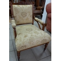 A late Victorian armchair with cream upholstered arms and seat, the back with carved detailing.