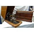 Two Victorian sewing machines in wooden cases. (2)