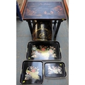 A Chinese lacquer table with brass fittings, together with three Chinese lacquer style graduated tra... 