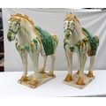 A pair of large 20th century Tang style horse figures, glazed in yellow and green, 57 by 50 by 19cm.... 