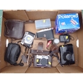 A collection of vintage cameras and accessories, including a Polaroid One Step Flash instant camera,... 