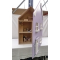 A modern wooden doll's house, painted light purple, containing various wooden figures, furniture and... 