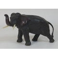 A Meiji period Japanese bronze model of an elephant, standing with trunk raised, ivory tusks, possib... 