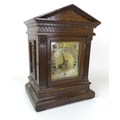 A late Victorian oak cased mantel clock, with musical movement stamped ‘W+H SGL’ chiming on four coi... 
