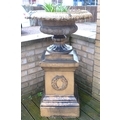 A buff terracotta Campana style pedestal urn, with lobed rim, on a square section pedestal base with... 