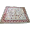 A Turkish large wool rug, with cream ground, scrolling floral decoration in yellow, red and pink, 33... 