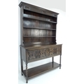 A mid 20th century oak dresser with two shelf plate rack, two panelled doors with an undertier unite... 