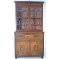 A George III inlaid mahogany secretaire bookcase, the flared cornice above vase and leaf scroll deco... 